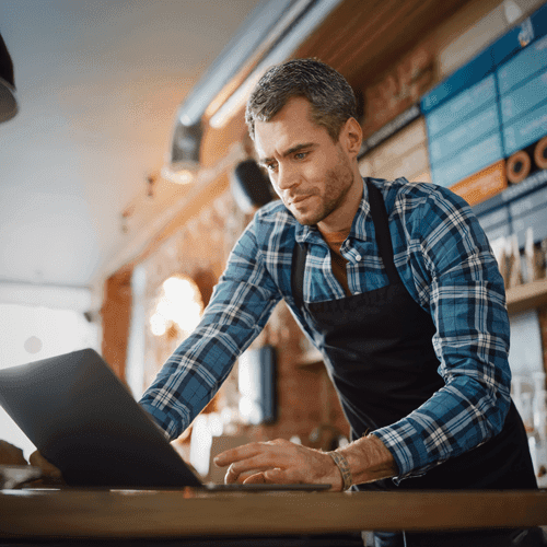 Coffee Shop Owner working on a laptop inside the store