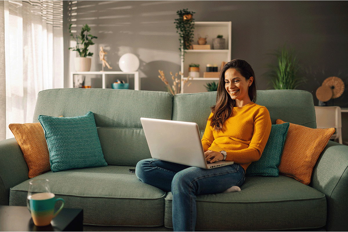 Woman sitting on her couch using a laptop