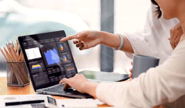 Two people looking at a laptop screen