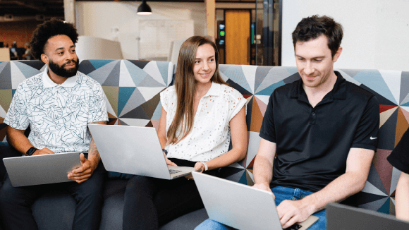 Three Simpli.fi employees collaborating in a co-working space at headquarters