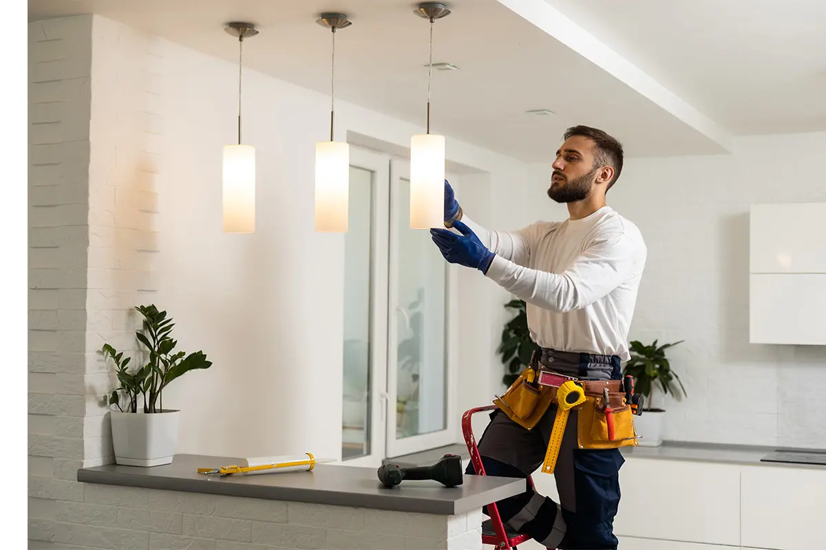 Electrician working on hanging overhead lights in a home