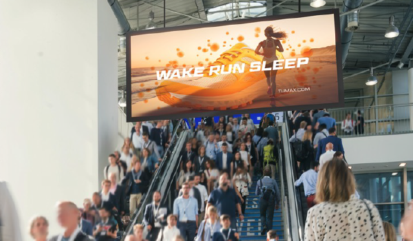 Billboard that reads Wake Run Sleep over a escalator full of people