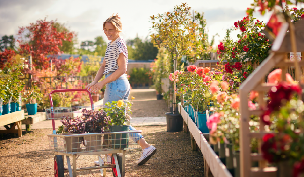 Woman with flowers in a shopping cart in a flower shop