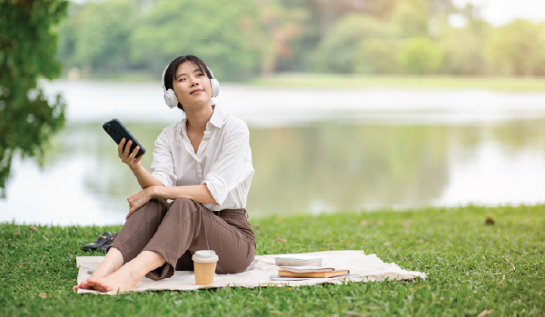 Woman with headphones on in a park