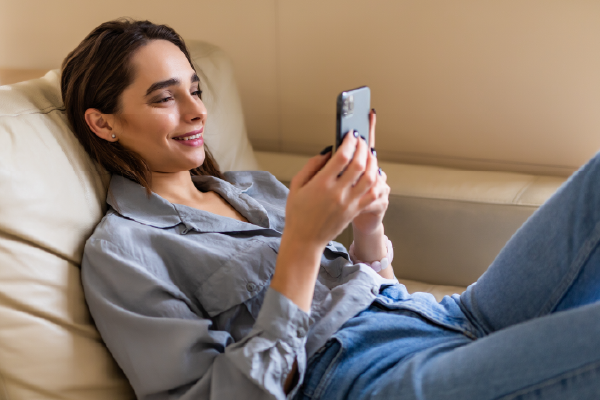 Marketer looking happy at a phone screen, showing that native ads are successful.