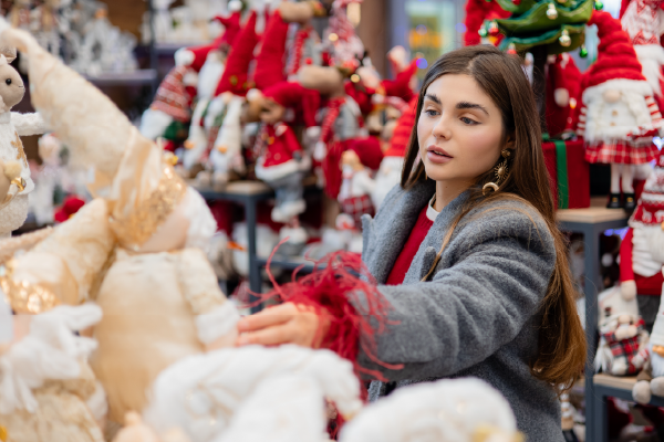 Woman shopping for Christmas ornaments and holiday decorations at a festive market stall